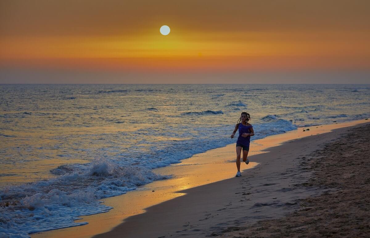 A person running at the sunset at the beach